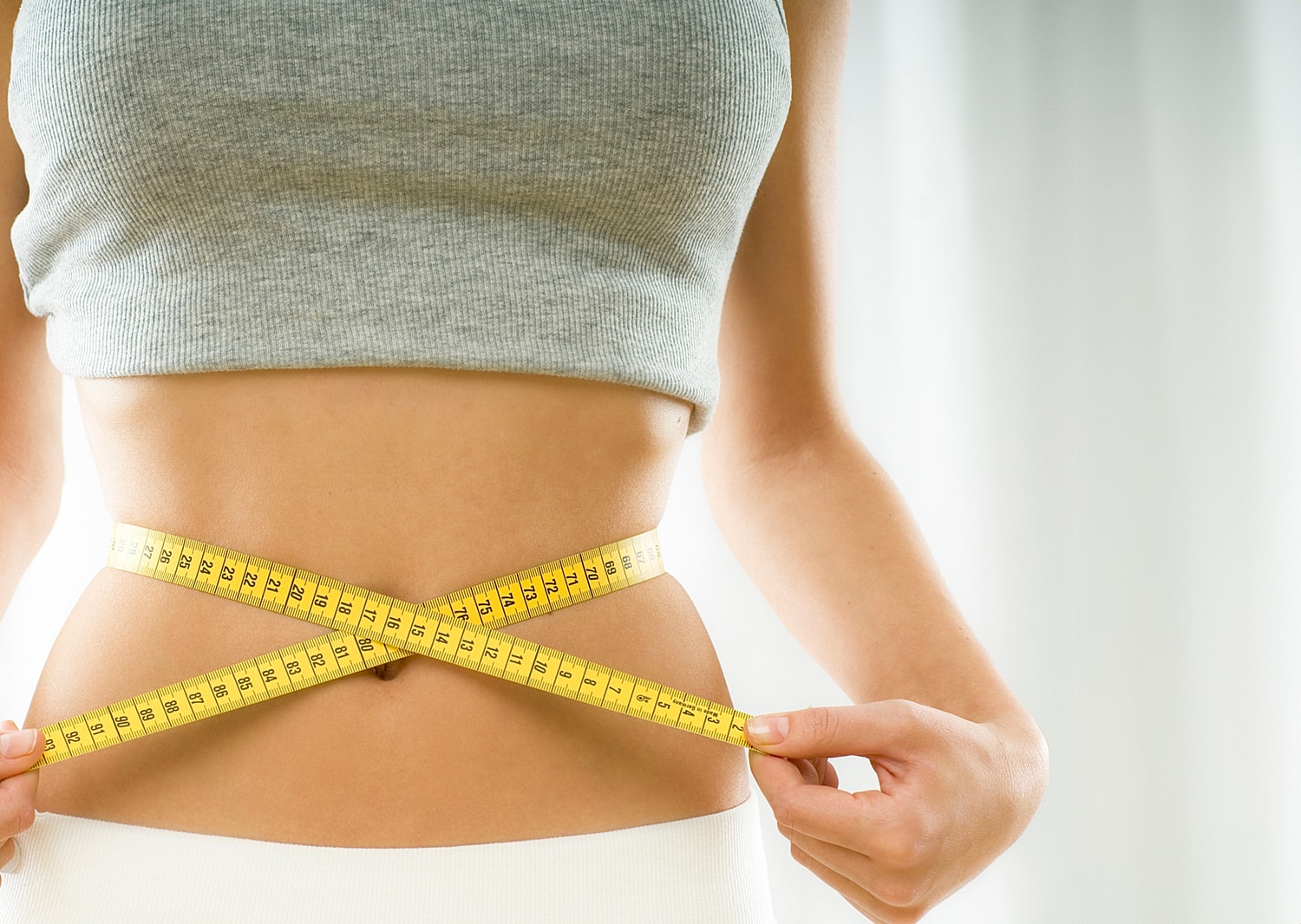 Measuring waist with tape measure on woman.