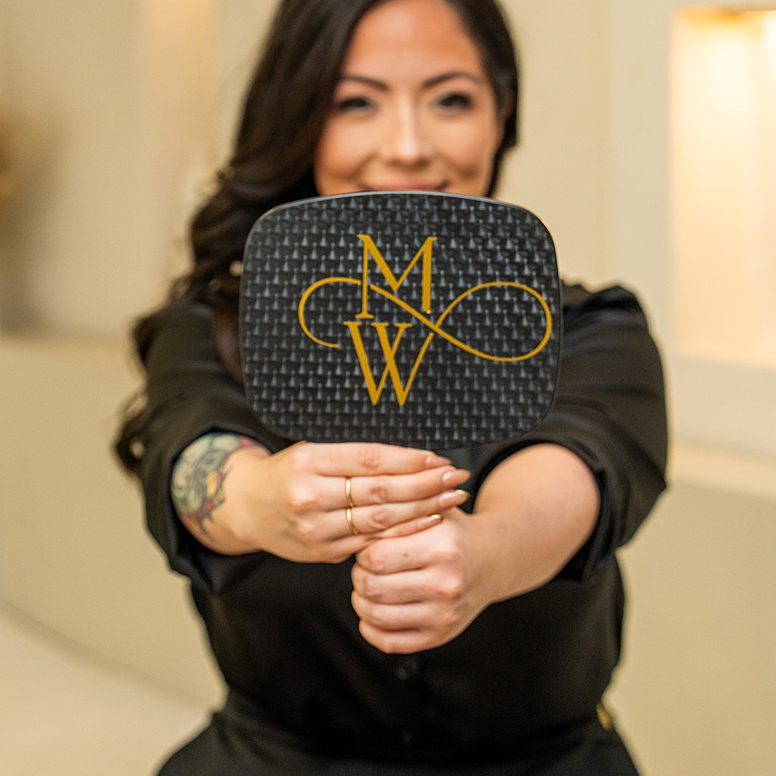 Woman holding a custom logo paddle mirror.